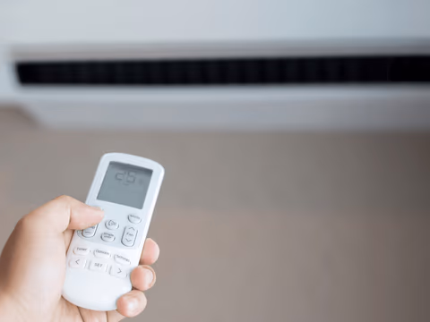 person holding an ac remote control